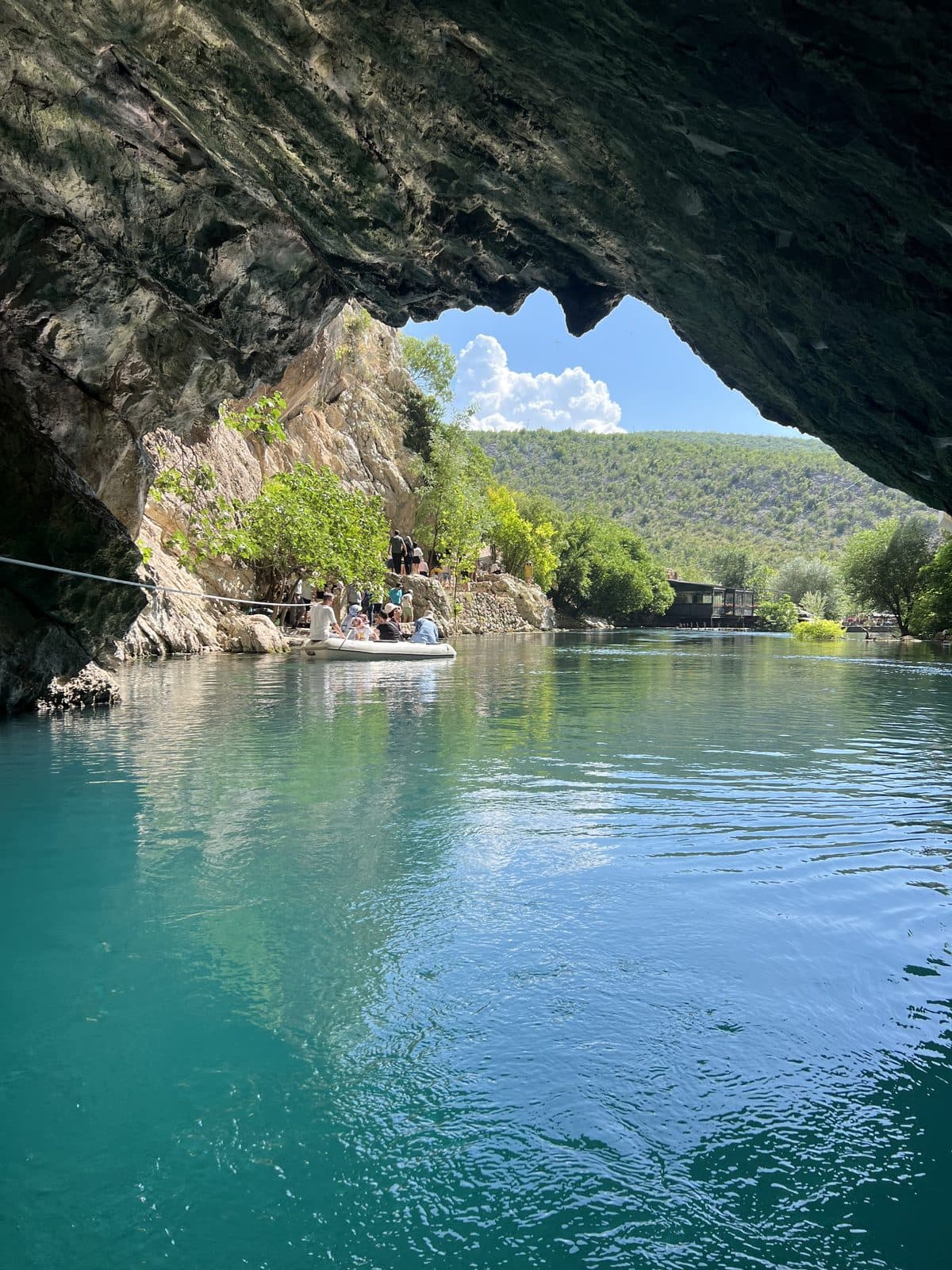 Turquoise river spring inside a riverside cave